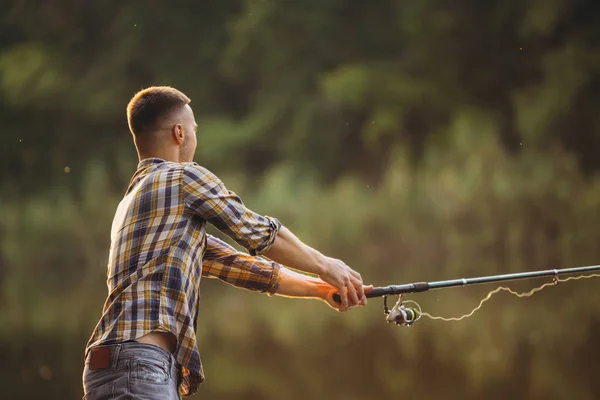 Ritratto ritagliato di giovane pesca sul fiume nella calda giornata estiva — Foto Stock