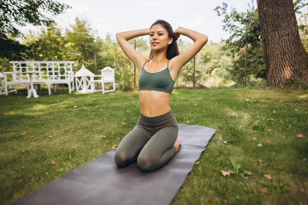 Ritratto a figura intera bella ragazza in forma che pratica yoga all'aria aperta — Foto Stock