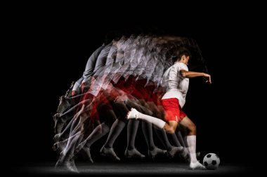 Stroboskop etkisi. Oyun bitti. Siyah arka planda izole edilmiş genç profesyonel futbolcu