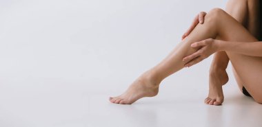 Gri arka planda iç çamaşırlı güzel ince kadın bacakları..