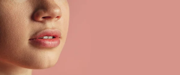 Ausgeschnittenes Frauengesicht-Porträt auf rosa Hintergrund. Schöne natürliche Lippen — Stockfoto