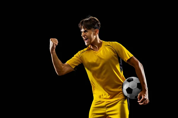 Ein männlicher Fußballprofi nach gewonnenem Spiel isoliert vor schwarzem Hintergrund — Stockfoto