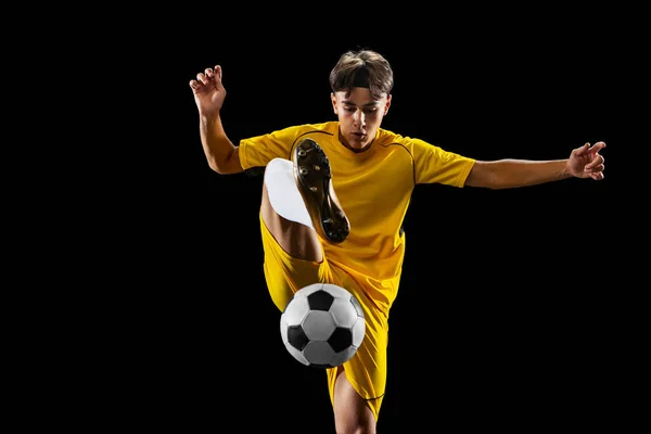 Bacl a figura intera ritratto del giovane, allenamento del giocatore di calcio isolato su sfondo nero. Dribbling — Foto Stock