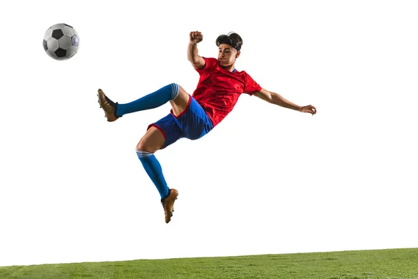 年轻足球运动员跳起球时的肖像 身穿红色和蓝色制服的运动员被隔离在白色背景之外 行动理念 团队运动 广告的复制空间 — 图库照片