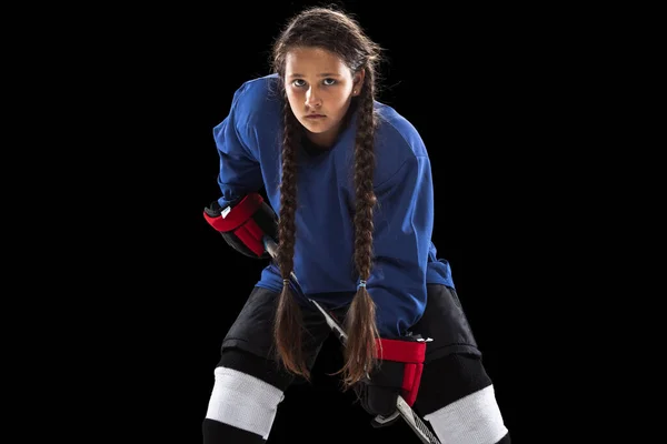 Una joven jugador de hockey entrenando aislado sobre fondo negro —  Fotos de Stock