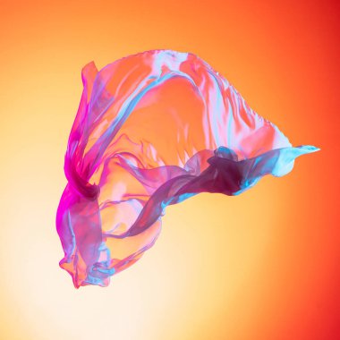 Soyut uçan çok renkli pembe mavi kumaş parçası. Gradyan kırmızı sarı stüdyo arka planında izole edilmiş.