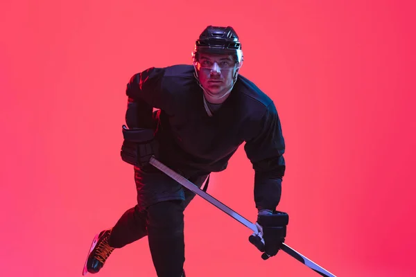 Retrato de jugador de hockey profesional aislado sobre fondo degradado en luz de neón — Foto de Stock