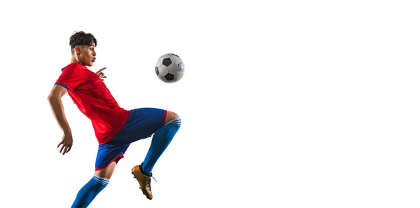Oříznutý portrét v pohybu mužského fotbalového hráče kopající míč s kolenem na trávě podlahy bílé pozadí — Stock fotografie