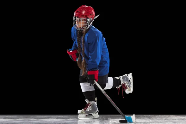 Ein Kind Mädchen, Hockeyspieler trägt spezielle Uniform, hält Hockeyschläger isoliert über schwarzem Hintergrund — Stockfoto