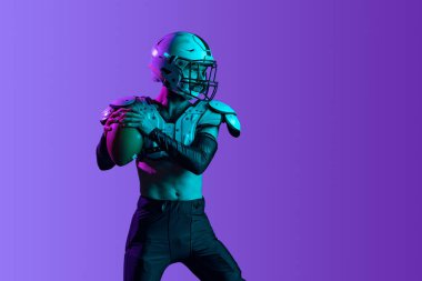 Mor arka planda izole edilmiş bir profesyonel Amerikan futbolcu eğitimi..