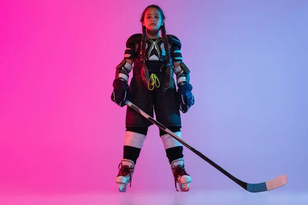 Retrato de larga duración de un niño jugando hockey profesional aislado sobre un fondo rosa púrpura degradado — Foto de Stock