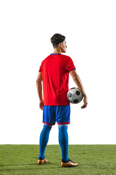Rückseite Porträt des jungen kaukasischen Fußballspieler i einheitliche Halten Ball isoliert auf Rasenboden weißen Hintergrund — Stockfoto