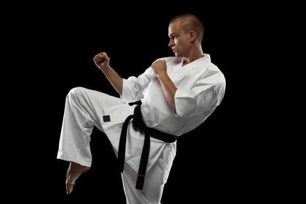 Retrato recortado de jovem esportista treinando karatê isolado sobre fundo preto — Fotografia de Stock