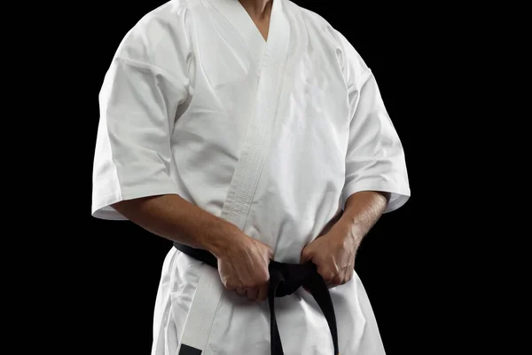 Retrato recortado de esportista masculino em quimono branco com faixa preta isolada sobre fundo escuro — Fotografia de Stock