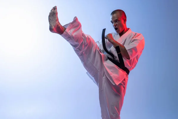Genç sporcunun karate eğitimi portresi, judo gradyan beyaz mavi arka planda izole edilmiş. — Stok fotoğraf