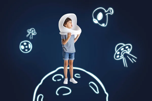 Art collage of little boy astronaut standing on drawing planet isolated over dark blue background — Stock Photo, Image