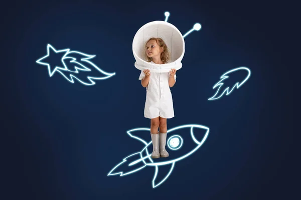 Creative artwork of little girl wearing astronaut helmet and standing on drawn rocket isolated over dark blue background with drawn asteroids