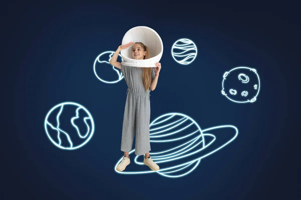 Творчество маленькой девочки в шлеме астронавта в космосе, изолированном на темно-синем фоне с нарисованными планетами — стоковое фото