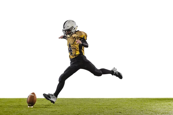 Jeden profesjonalny amerykański piłkarz w specjalnym mundurze kopanie piłkę z nogą izolowane nad białą trawą podłogi tła — Zdjęcie stockowe