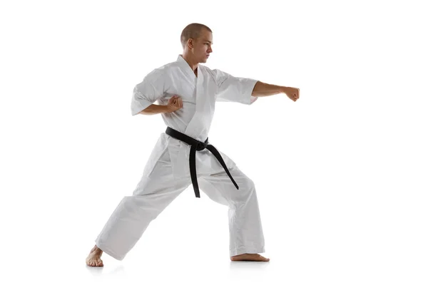 Full-length portret van Kaukasische sportman staande in punch pose geïsoleerd over witte achtergrond. Karate, judo, taekwondo sport — Stockfoto