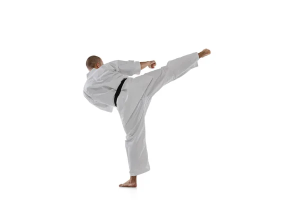 Bakåt. Full längd porträtt av kaukasisk idrottsman stående i sidan kick pose isolerad över vit bakgrund. Karate, judo, taekwondo sport — Stockfoto