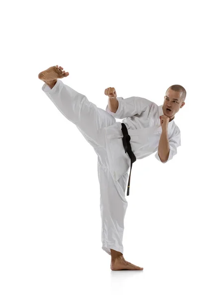 Full längd bild av en professionell idrottsman stående i sidokick pose isolerad över vit bakgrund. Karate, judo, taekwondo sport — Stockfoto