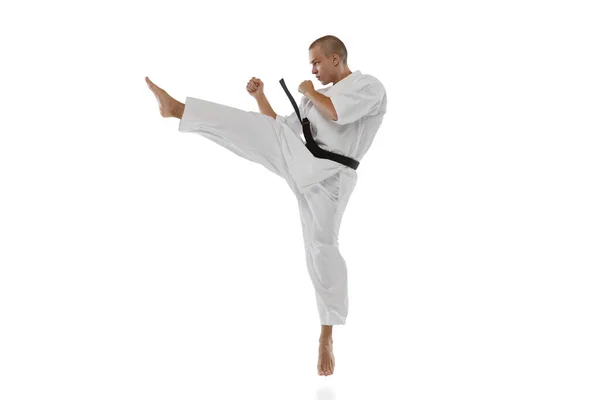 Ein kaukasischer Sportler, der in Side-Kick-Pose steht, posiert isoliert vor weißem Hintergrund. Karate, Judo, Taekwondo — Stockfoto