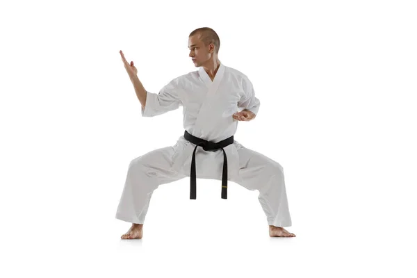 Full-length portrait of caucasian sportsman standing in a fight pose isolated over white background. Karate, judo, taekwondo sport — Stock Photo, Image