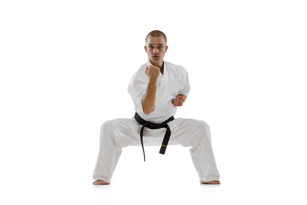 Full-length portret van Kaukasische sportman staan in een gevecht pose geïsoleerd over witte achtergrond. Karate, judo, taekwondo sport — Stockfoto