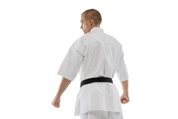 Achteraanzicht portret van professionele karateka in kimono met zwarte band geïsoleerd over witte achtergrond. Karate, judo, taekwondo sport — Stockfoto