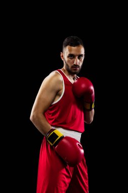 Siyah arka planda izole edilmiş kırmızı üniformalı genç profesyonel boksörün kırpılmış görüntüsü. Sportif ve sağlıklı yaşam tarzını sürdürüyor. Sağlık, spor, hareket konsepti. İlan için alanı kopyala.