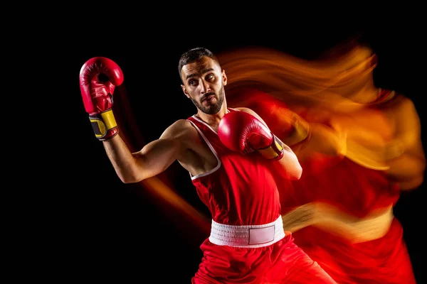 Oldalnézet vágott kép egy profi bokszoló piros rövidnadrág képzés, gyakorlása elszigetelt fekete háttér vegyes fényben — Stock Fotó