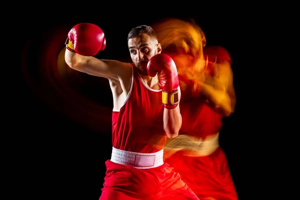 Treinamento boxeador masculino profissional isolado sobre fundo preto em luz mista. Efeito de luz mista — Fotografia de Stock