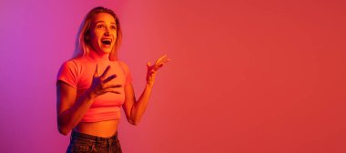 Beyaz bir kız, neon ışıklarla izole edilmiş arka planda poz veriyor.