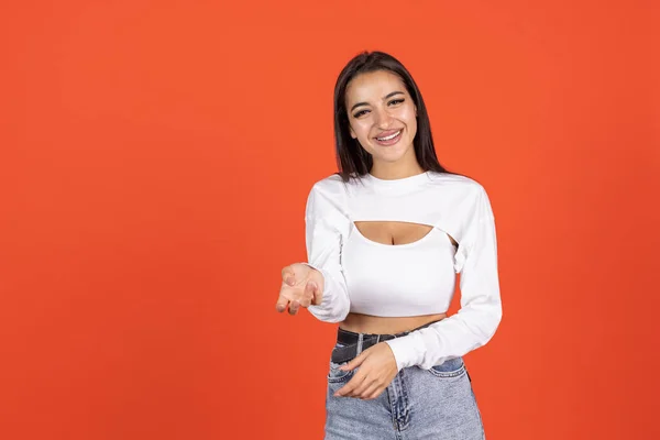 Portret van een prachtig blank meisje in modieuze kleding, geïsoleerd poserend over oranje achtergrond. Lachende schoonheid — Stockfoto