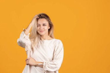 Sarı arka planda yalnız poz veren güzel beyaz bir kız. Merakla bakıyorum.