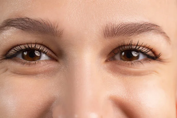 Imagen recortada de cerca de hermosos ojos marrones femeninos que muestran diferentes emociones. Ojos sonrientes. —  Fotos de Stock