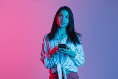 Güzel bir genç kız, neon ışıklarda pembe bir arkaplanda izole edilmiş. Metin