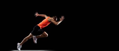 Genç profesyonel sporcu erkek sporcunun tam boy portresi, siyah stüdyo arka planında izole edilmiş. El ilanı