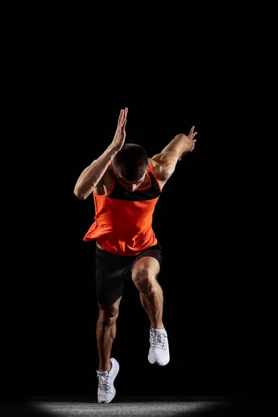 Retrato de vista frontal de cuerpo entero de un joven atleta profesional corriendo, entrenamiento aislado sobre fondo de estudio negro —  Fotos de Stock