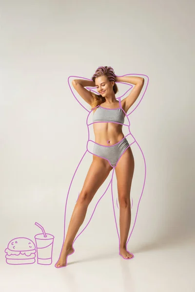 Ung vacker kvinna med perfekt smal kropp i inre slitage isolerad över grå bakgrund. Begreppet hälsa och lämplighet — Stockfoto