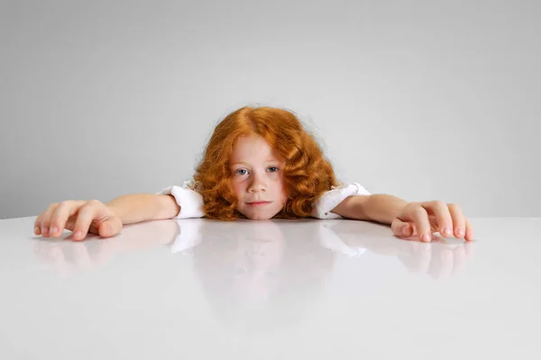 Портрет маленької кавказької милої дівчинки, що висить ізольовано над сірим фоном студії. — стокове фото