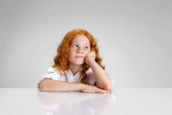 Portré kis kaukázusi aranyos vörös hajú lány pózol elszigetelt felett szürke stúdió háttér. — Stock Fotó