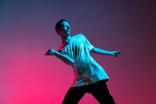 Retrato horizontal recortado de un joven bailarín de hip-hop masculino practicando aislado sobre un fondo rosa púrpura degradado en luz de neón —  Fotos de Stock