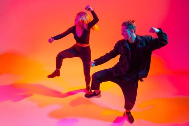 İfade. Rengarenk arka planda iki güzel hip-hop dansçısı neon ışıklarıyla