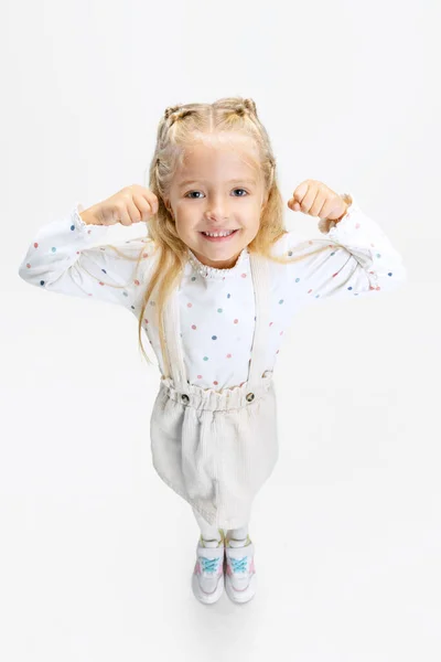 Top vista retrato de menina caucasiana pequena, criança posando isolado sobre fundo estúdio branco. — Fotografia de Stock