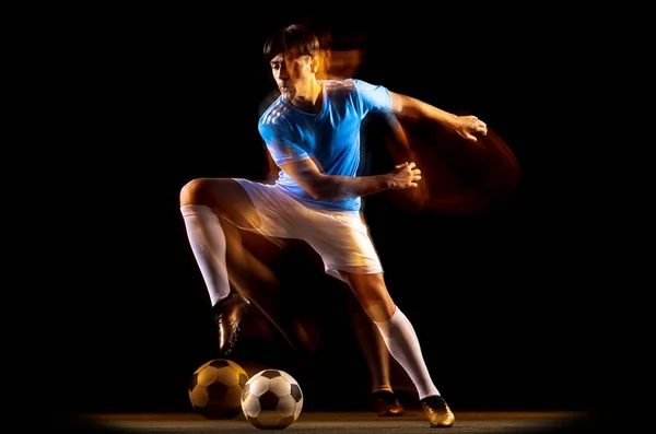 Młody sportowiec, trenujący piłkarza, odizolowany od czarnego tła w świetle mieszanym. Big Chance cel — Zdjęcie stockowe