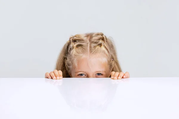 Portret dziewczynki z przedszkola, dziecko bawiące się w chowanego gra izolowana na białym tle studio. — Zdjęcie stockowe