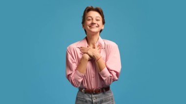 Grateful smiling woman with hands on chest expressing kindness and warmth. Concept of empathy, gratitude, and emotional connection for psychology, HR, and educational campaigns.