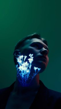 Boynunda parlak botanik projeksiyonu olan bir adam karanlık, kasvetli ışığın altında yan tarafa bakıyor. Sanatsal başyazılar, modern kampanyalar ve tasarım kullanımı için öz yansıma, duygu, yaratıcı kimlik kavramı.